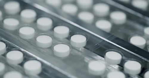 Factory equipment and machine. Closeup view of drugs move along conveyor belt.