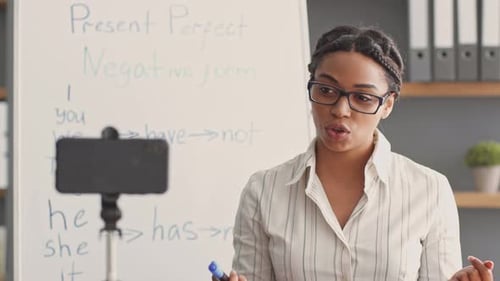 Female Tutor Teaching Online Using Phone Camera