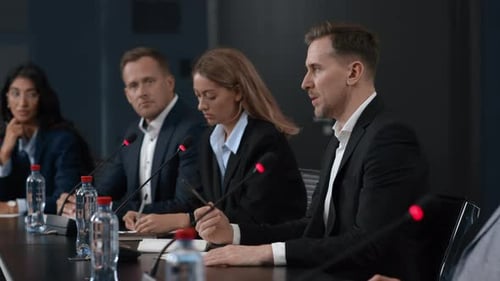 Business Professionals at Conference Speaking at Table