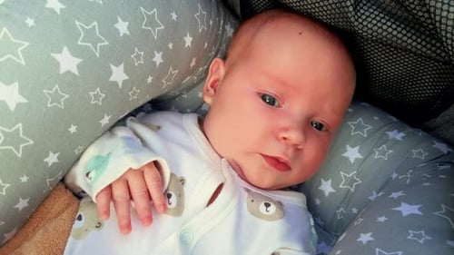 Infant Opens Eyes in a Cozy Bassinet