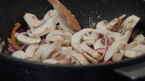 Stirring Vegetables in Pan with Wooden Spoon