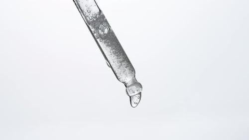 Clear Liquid Slowly Dripping from Glass Pipette