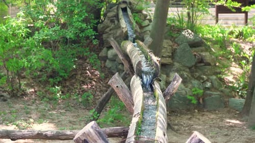 Clear fresh water flowing through open wooden pipes in Korean folk village Yongin City, Korea wide a