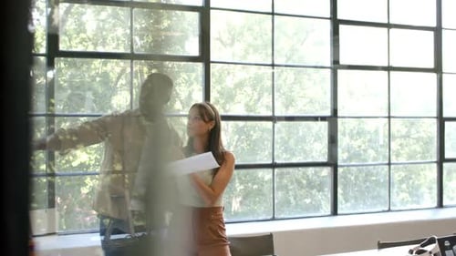 Discussing project, colleagues holding documents and tablet in modern office setting, copy space