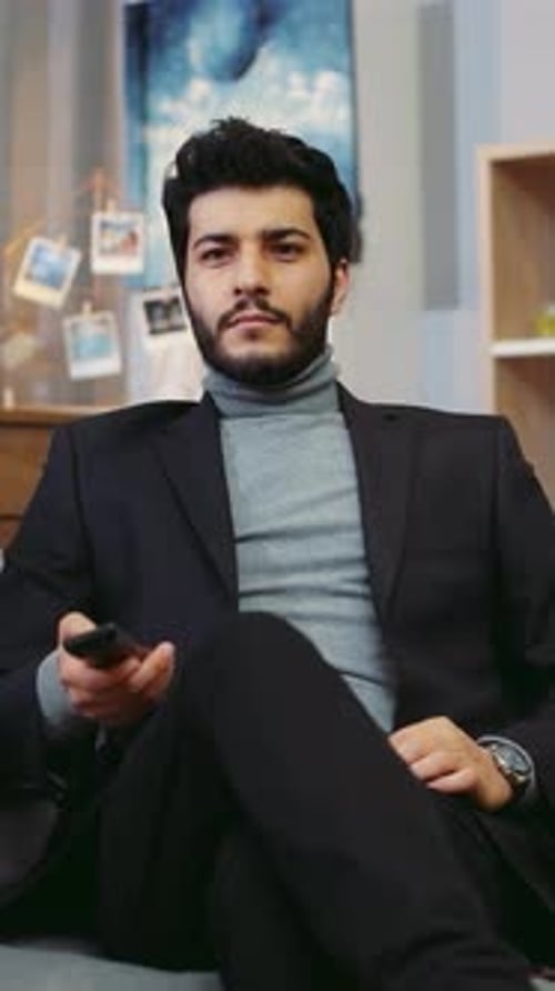 A Man in a Suit Relaxes in a Stylish Living Room Using His Phone