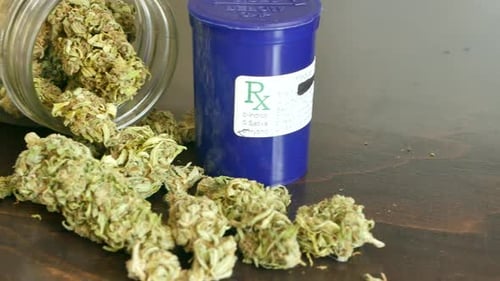 PAN LEFT Marijuana buds and Rx jar for recreational or prescription medicinal weed smoking.