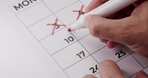Marking Dates Off Calendar With Red Marker