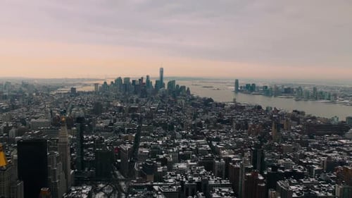 Sweeping view of Manhattan skyline from Empire State Building on cloudy winter day. The city's iconi