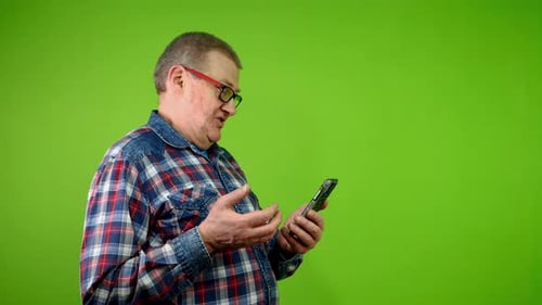 Adult Man Talking on Smartphone with Green Background