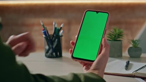Person Swiping Green Screen on Mobile Phone