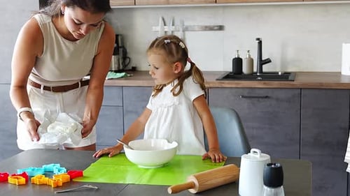 Woman and Girl Cooking in Kitchen