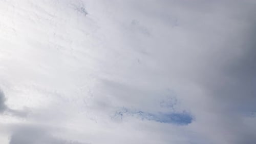 Fast Moving Fluffy Clouds Against Blue Sky