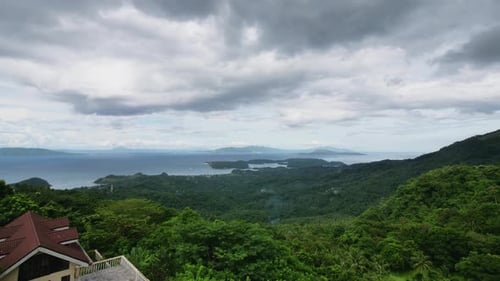 Weiße Wolken über dichten grünen Wäldern an Berghängen