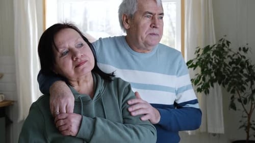Senior Couple Embracing Tenderly Indoors Near a Window