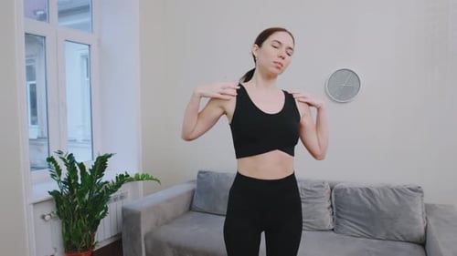 Femme faisant de l'exercice à l'intérieur dans un salon effectuant des exercices pour les bras pour améliorer sa force et sa forme physique