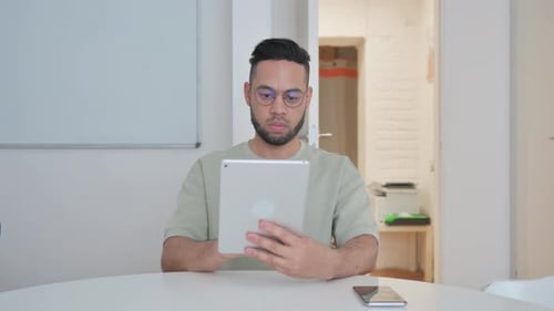 Man Using Tablet at Desk Indoors