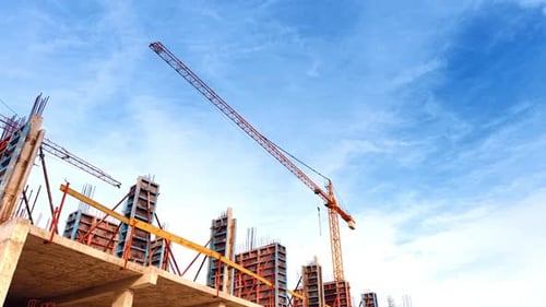 Metal armature on the top of the construction and a crane above. Low angle perspective.