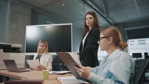 Business team discusses documents in modern office setting during a collaborative meeting