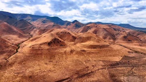 Bare brown rocky landscape with no vegetation. Overcast sky over the scenery. West Crystal, Utah