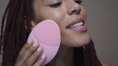 Woman Cleansing Face with Facial Brush