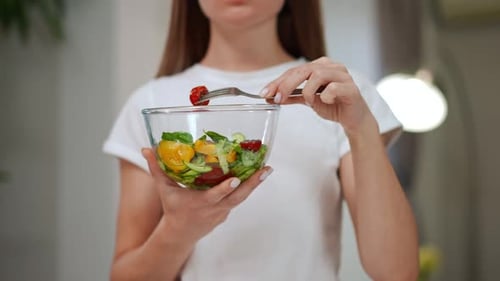 Young Adult Woman Enjoys Healthy Salad Indoors