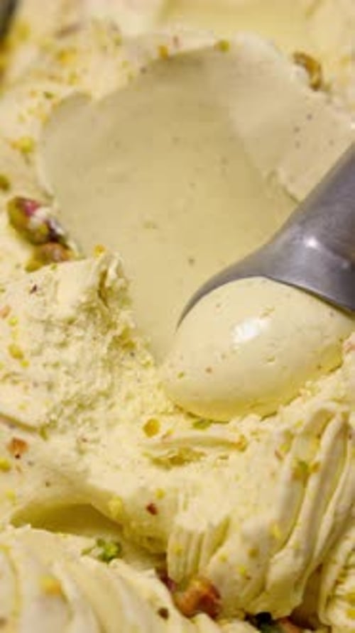 Scoop Portion of Ice Cream From Container with Spoon