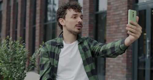 Man Chatting Via Video Call in Urban Setting