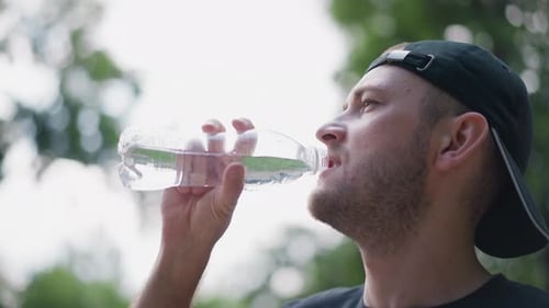 Hydrated Man Drinks Water From Bottle Outdoors Close-up