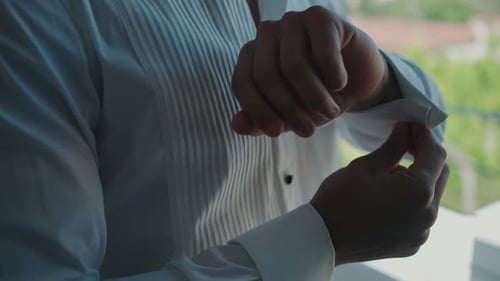 Man Dressed in White Shirt Fastening Cufflinks Indoors