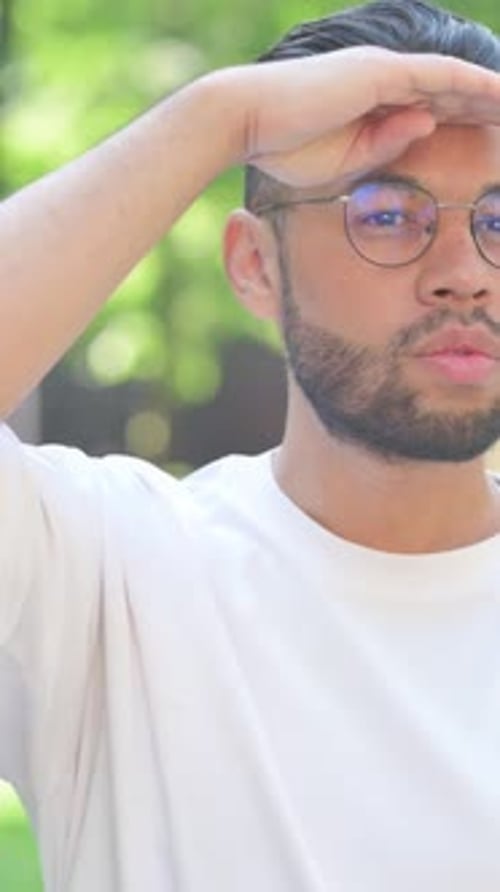 Vidéo verticale, jeune homme à la recherche d'une nouvelle opportunité en plein air dans un parc