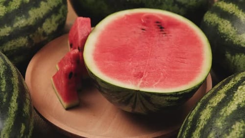 Close-up shot of half pieces of fresh red watermelons on a wooden dish.