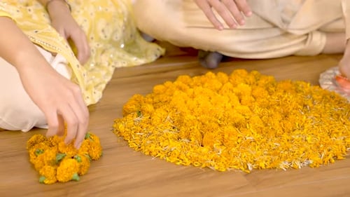 Adults Arranging Marigold Flowers for a Celebration