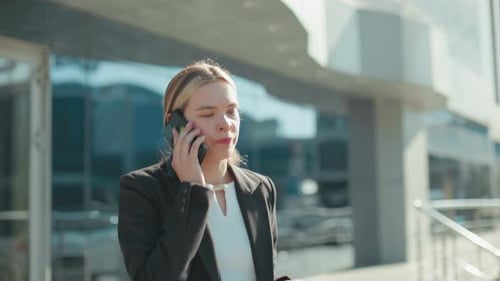 Woman Talking on Phone Outside Modern Building