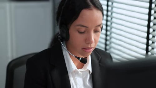 Competent Female Operator Working on Computer and While Talking with Clients