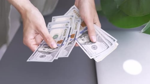 Nahaufnahme der Hände einer Frau beim Zählen von Bargeld, 1000 amerikanischen Dollar, Banknoten, Einkommensgewinner und Geschäft