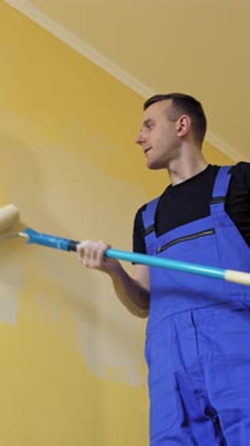 Mann macht neue Zimmereinrichtung mit Farbe. Junger gutaussehender Mann bei der Renovierung. Vertikales Video