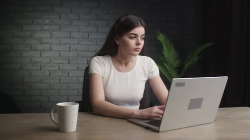 Tired Woman Working on Laptop at Desk
