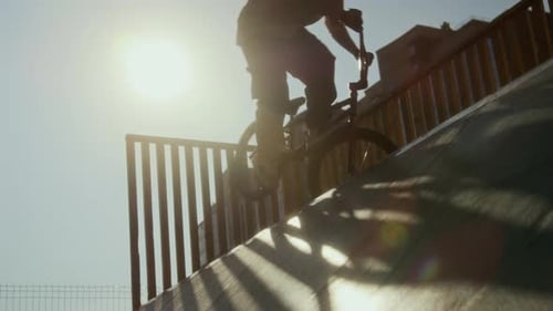 BMX Rider Practicing Stunt on Bike at Skatepark Ramp