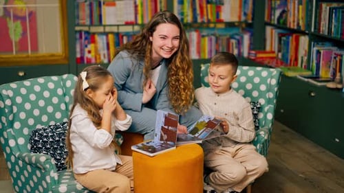 in Bookstore in the Children Area Beautiful Girl and Boy Their Mother to Read Them a Book