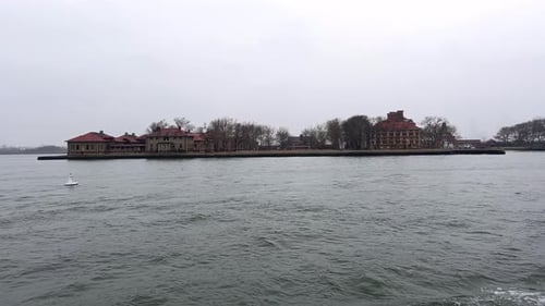 Moody view from boat of Ellis Island from water in New York, USA