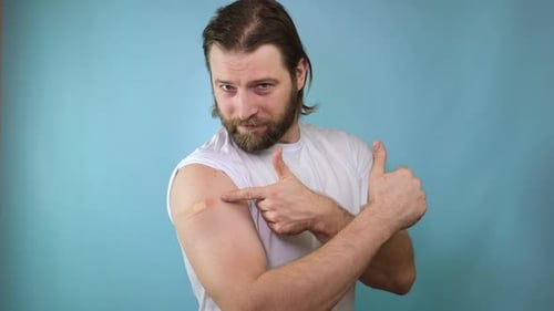 Man Points to Bandage and Gives Thumbs Up