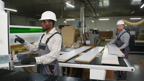 Two Workers Cutting and Stacking Furniture Panels