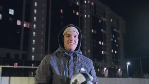 Young Man with Soccer Ball at Night