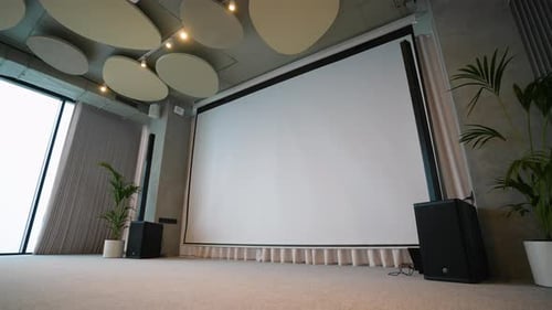 Empty Presentation Room with Large Screen and Speakers