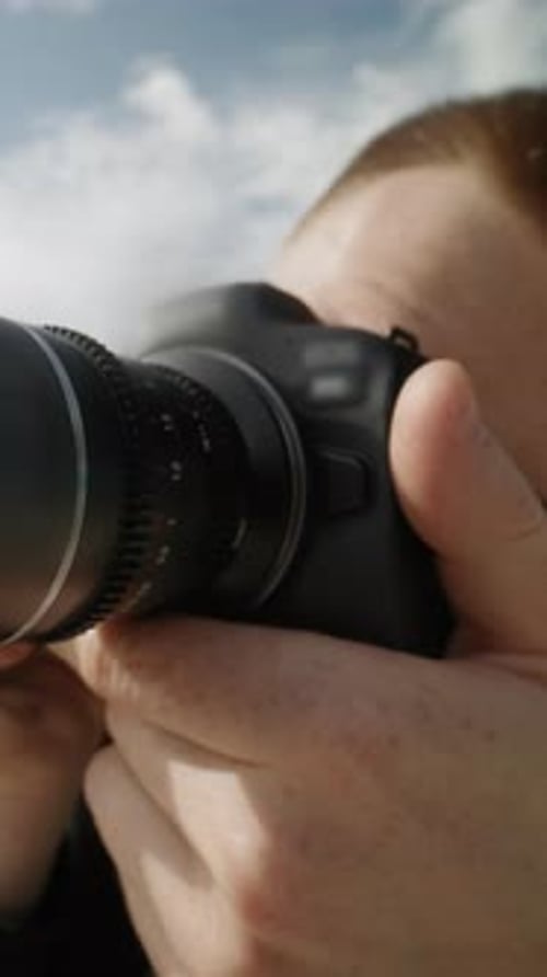 A Closeup Shows a Man Intently Focusing on a Photograph with a Camera