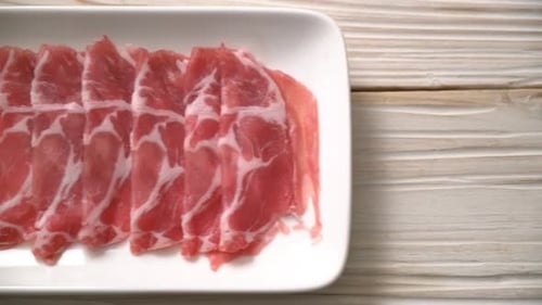 Thin Slices of Raw Pork on White Plate