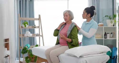 Senior Woman Receives Shoulder Therapy From Young Therapist