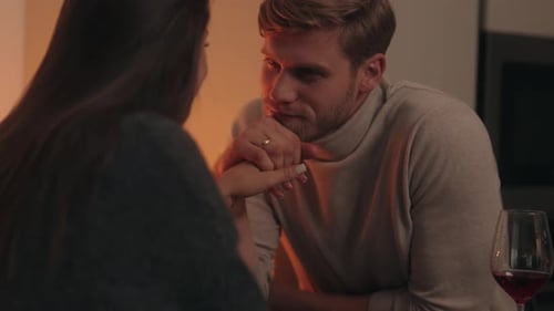 Affectionate Couple Holding Hands Indoors Over Wine