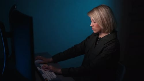 Blonde Haired Person Uses a Computer at Night