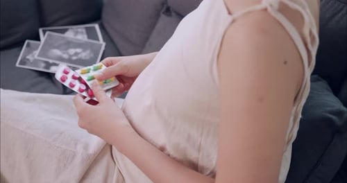 Pregnant Woman with Pills and Sonogram Photos